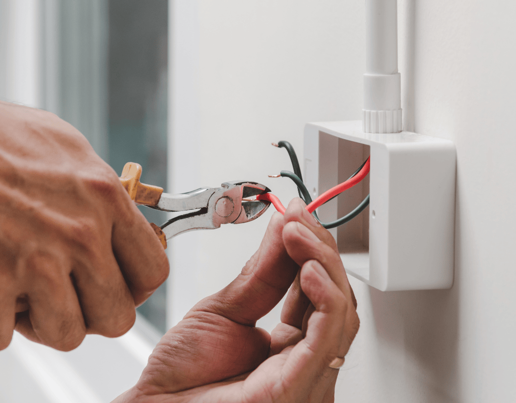 Electrician cutting and connecting wires during electrical repair service in North Shore MA